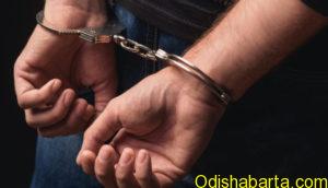 Young criminal standing in handcuffs